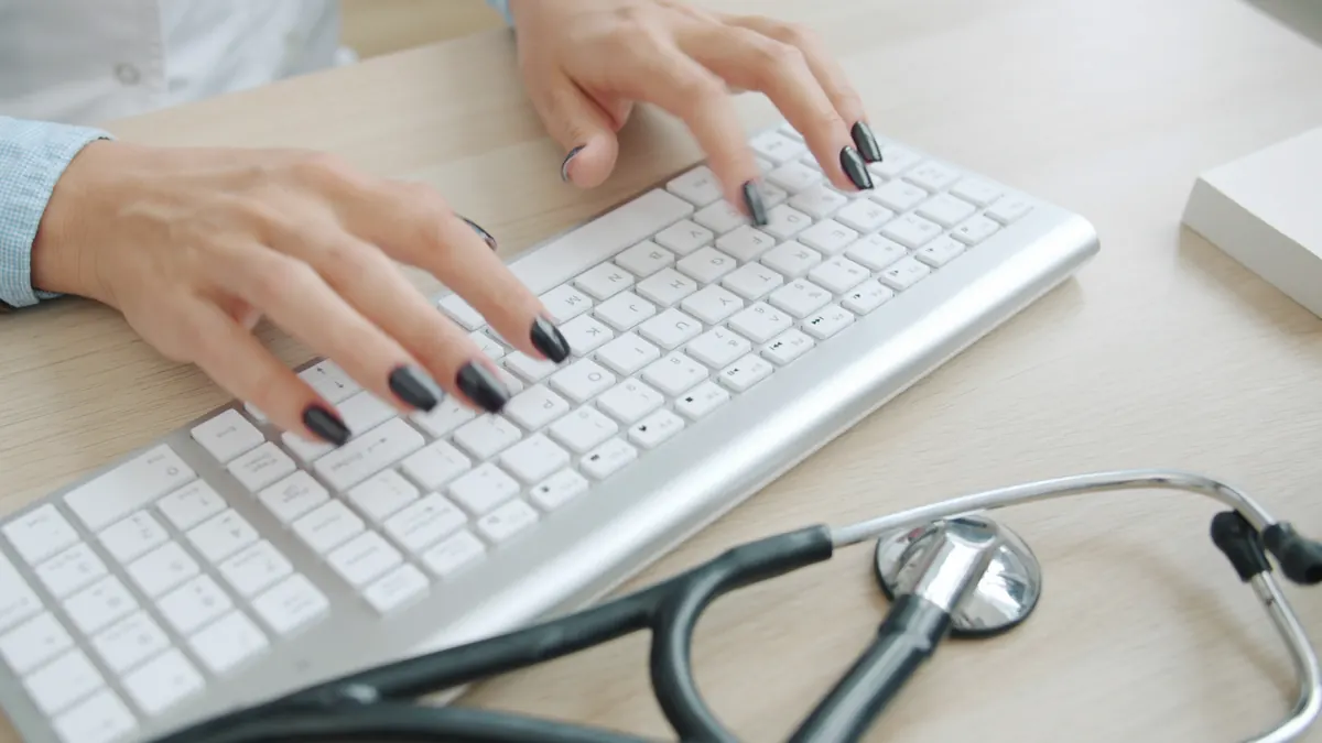 Mãos de profissional de saúde digitando no teclado, com estetoscópio sobre a mesa